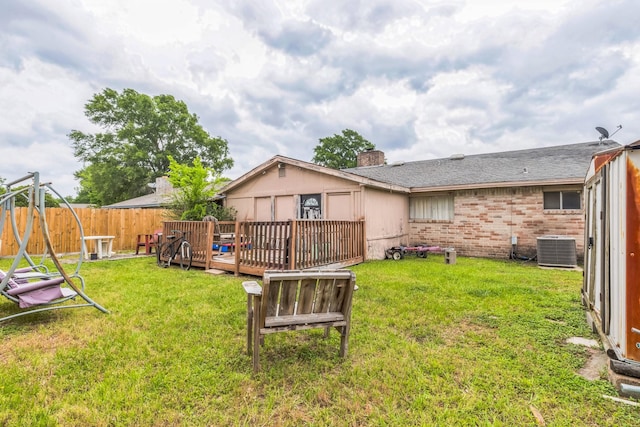 view of yard featuring fence, a wooden deck, and cooling unit
