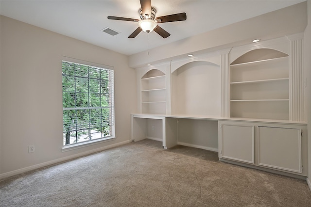 empty room with baseboards, ceiling fan, light colored carpet, and visible vents