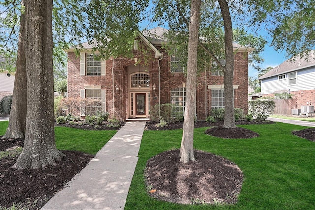 view of front facade featuring brick siding and a front lawn