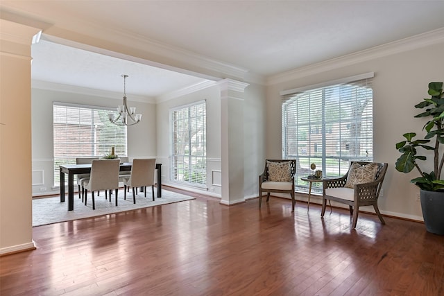 sitting room with ornamental molding, an inviting chandelier, plenty of natural light, and wood finished floors