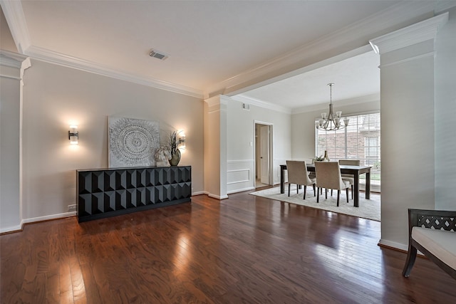 interior space with visible vents, crown molding, wood finished floors, and an inviting chandelier