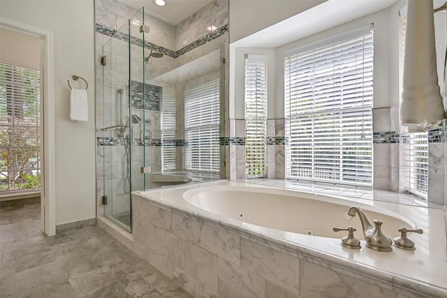bathroom featuring a whirlpool tub, baseboards, and a shower stall