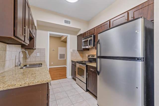 kitchen with visible vents, appliances with stainless steel finishes, dark brown cabinets, a sink, and light tile patterned flooring