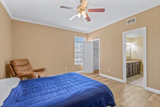 bedroom with visible vents, a sink, crown molding, and light wood-type flooring