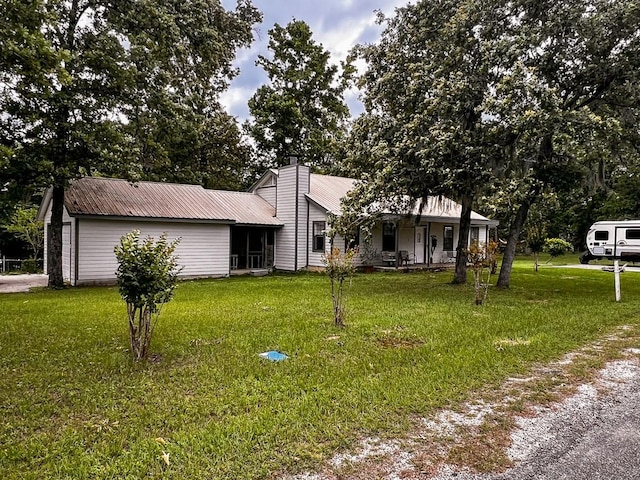 view of front facade featuring a porch, a front lawn, and metal roof