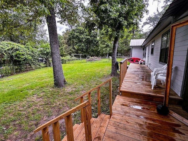 wooden deck with a lawn and fence