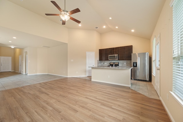 kitchen with light wood finished floors, dark brown cabinetry, high vaulted ceiling, and stainless steel appliances