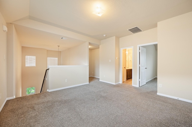 unfurnished room with visible vents, baseboards, and light carpet