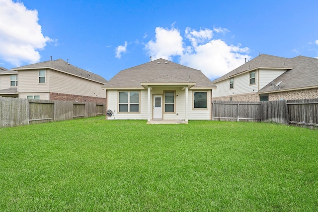 rear view of house featuring a fenced backyard, a patio, and a lawn