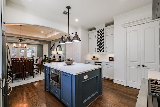 5336 Inker St, Houston, TX 77007 - kitchen with white cabinets, blue cabinetry, stainless steel appliances, visible vents, and ornamental molding