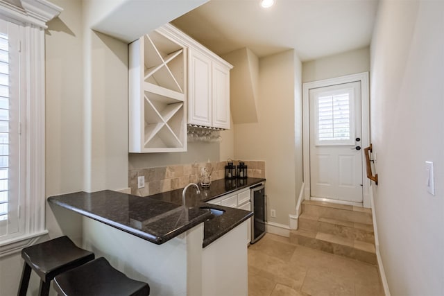 5336 Inker St, Houston, TX 77007 - kitchen with open shelves, a sink, a kitchen breakfast bar, white cabinetry, and a peninsula