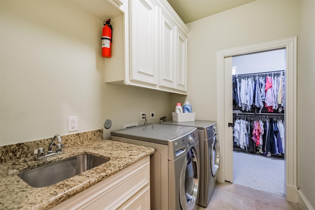 5336 Inker St, Houston, TX 77007 - laundry room featuring cabinet space, washing machine and clothes dryer, light colored carpet, a sink, and light tile patterned floors