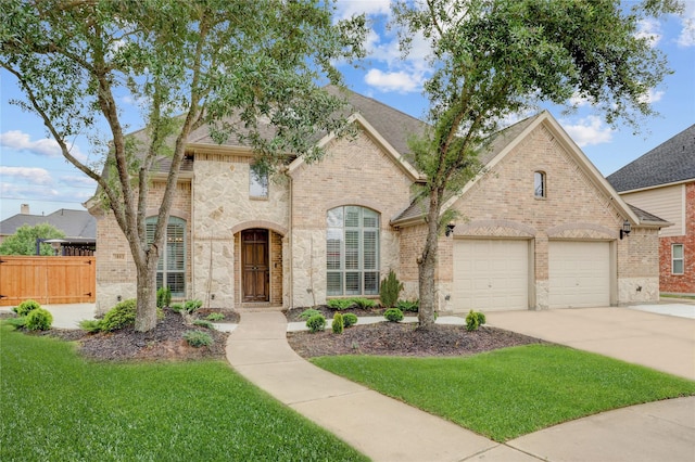 french country home featuring fence, driveway, a front lawn, and brick siding