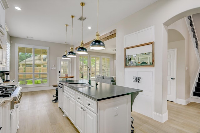 kitchen with visible vents, a sink, dark countertops, and stainless steel dishwasher