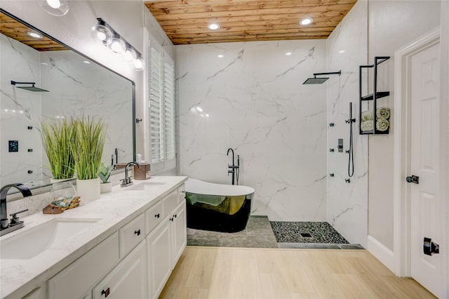 bathroom with a sink, a marble finish shower, and a freestanding tub