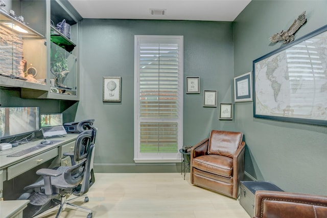 office space with visible vents, baseboards, and wood finished floors
