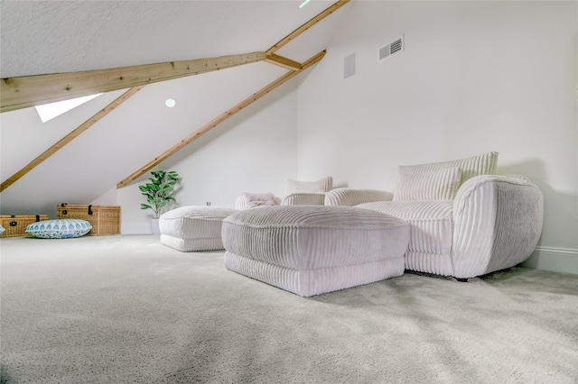 sitting room with carpet floors, visible vents, and vaulted ceiling with skylight