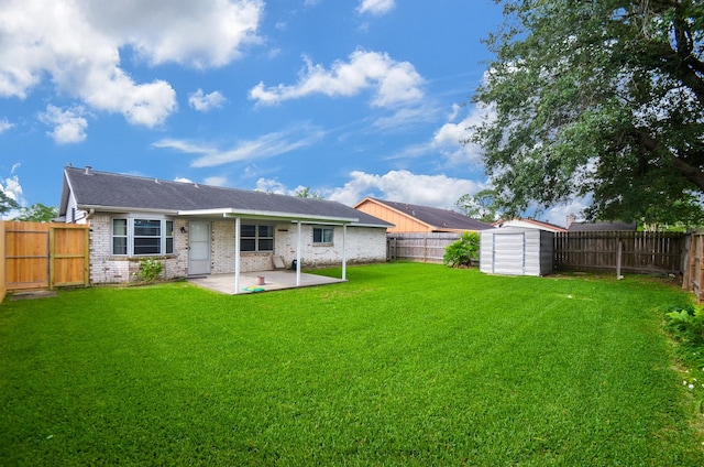 rear view of house featuring a fenced backyard, a patio, a yard, and brick siding