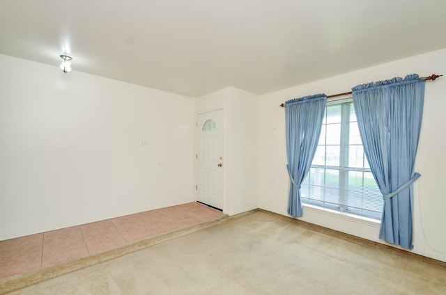 tiled spare room featuring carpet flooring