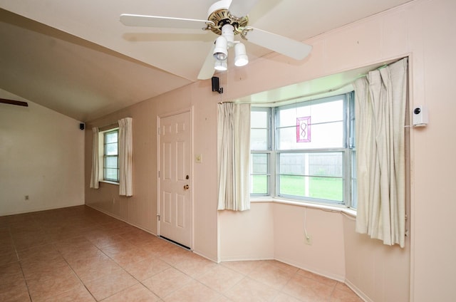 spare room featuring baseboards, ceiling fan, lofted ceiling, and light tile patterned floors