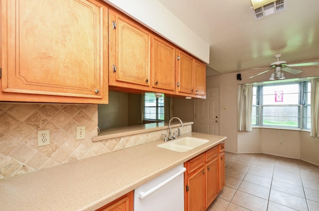 kitchen featuring ceiling fan, a sink, dishwasher, light countertops, and tasteful backsplash