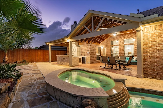 view of swimming pool featuring fence, a patio, and an in ground hot tub