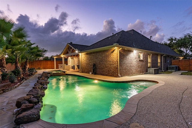 view of pool with central air condition unit, a pool with connected hot tub, a fenced backyard, and a patio area