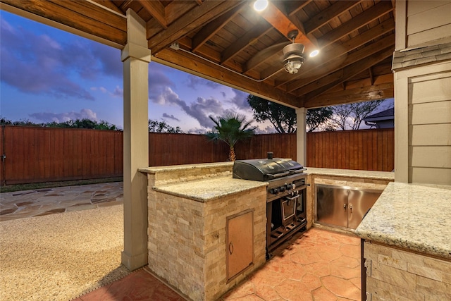 view of patio with a fenced backyard, grilling area, and exterior kitchen