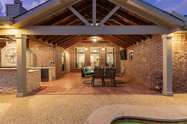 view of patio featuring outdoor dining area, exterior kitchen, and a gazebo
