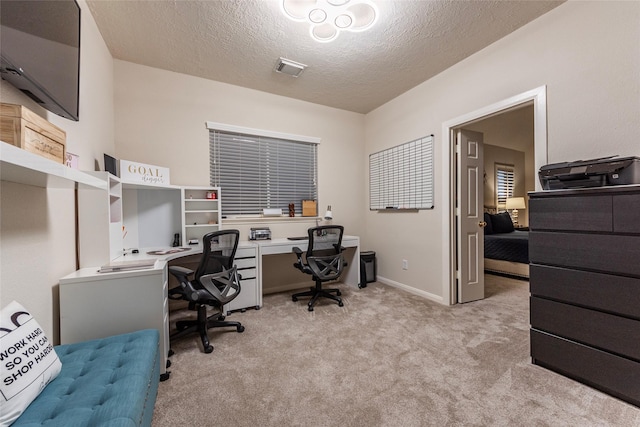 home office featuring baseboards, light carpet, and a textured ceiling