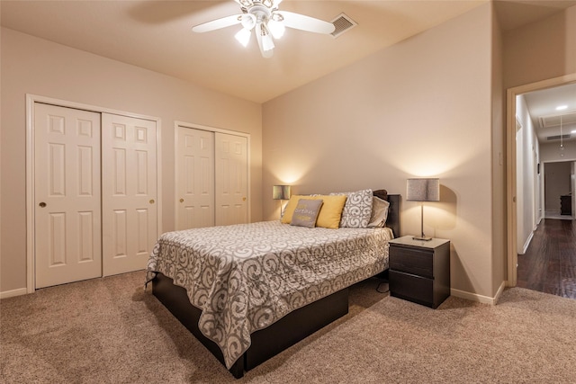 bedroom featuring attic access, visible vents, baseboards, two closets, and carpet