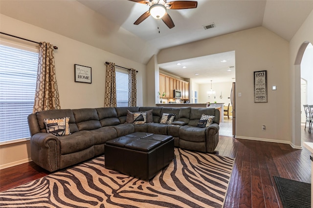 living room featuring visible vents, ceiling fan, dark wood-style floors, arched walkways, and vaulted ceiling