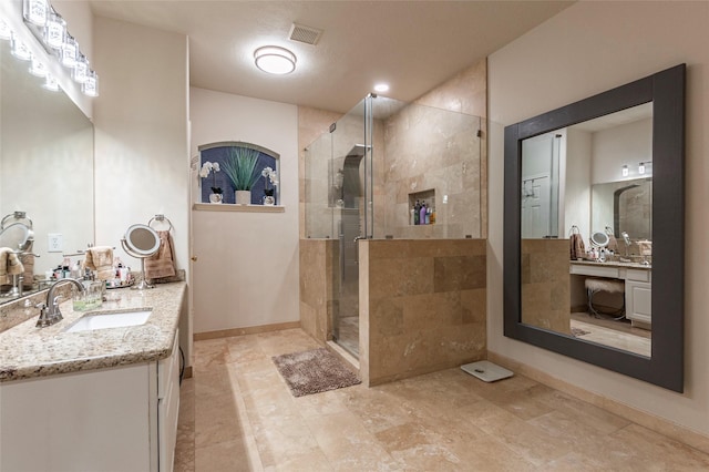 full bathroom featuring vanity, baseboards, visible vents, and a stall shower