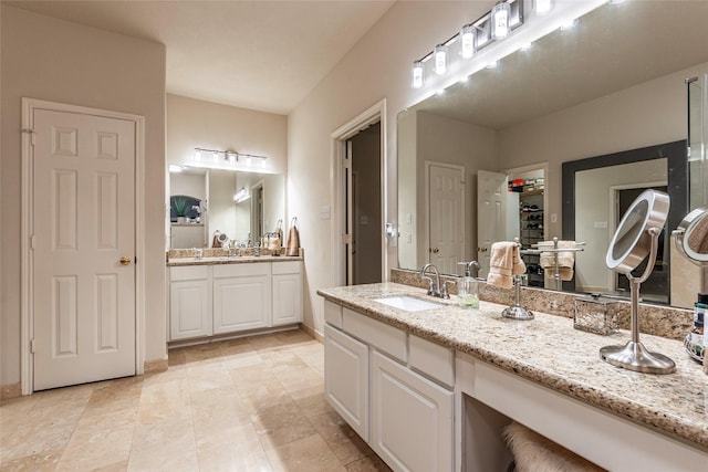 full bathroom featuring a sink and two vanities