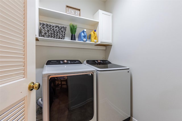 washroom featuring independent washer and dryer and cabinet space