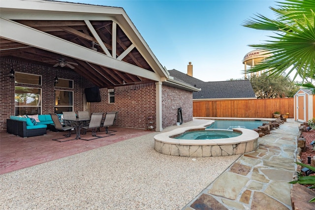 view of swimming pool featuring ceiling fan, a patio, a storage shed, an in ground hot tub, and an outbuilding