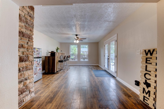 foyer entrance featuring dark wood-style flooring, a textured ceiling, french doors, a ceiling fan, and baseboards