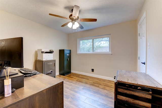home office featuring baseboards, a ceiling fan, and light wood-type flooring
