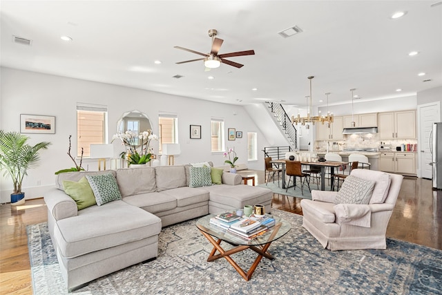 living area featuring recessed lighting, ceiling fan with notable chandelier, wood finished floors, and visible vents