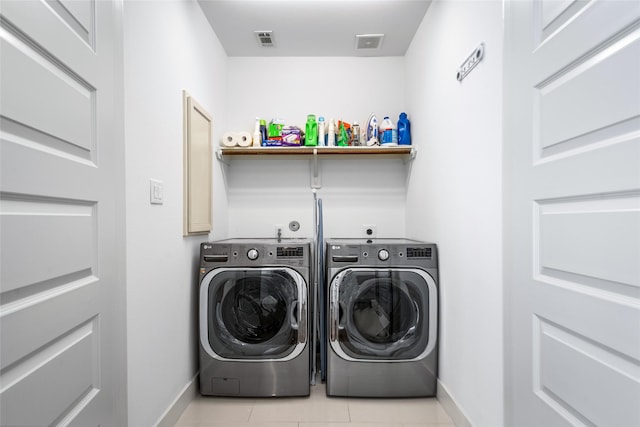laundry area featuring baseboards, laundry area, washing machine and dryer, and visible vents