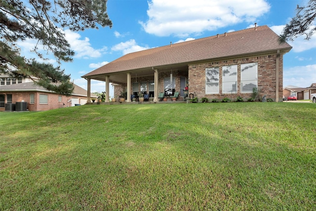 rear view of property with a lawn, brick siding, roof with shingles, and central air condition unit