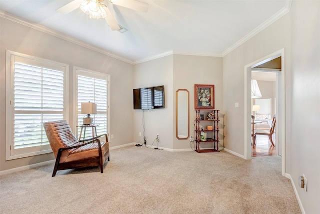 living area with crown molding, ceiling fan, light carpet, and baseboards
