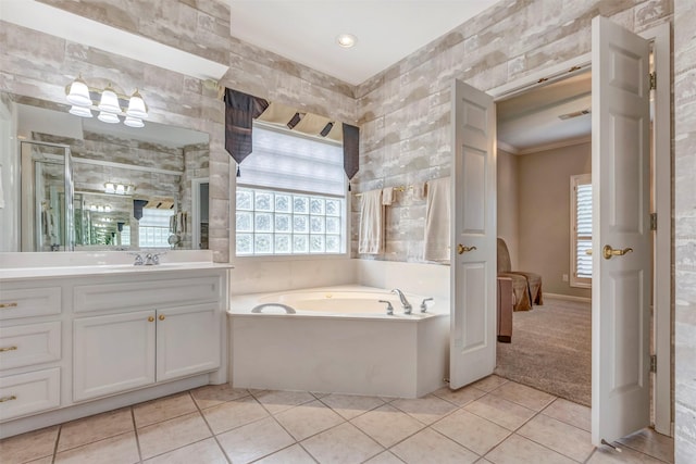 full bath featuring vanity, a bath, tile patterned floors, and a healthy amount of sunlight