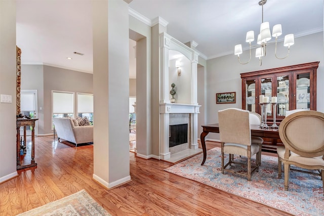dining space featuring crown molding, baseboards, and light wood-type flooring