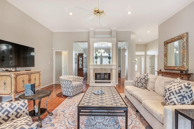 living room with crown molding, ceiling fan, baseboards, and light wood-style floors