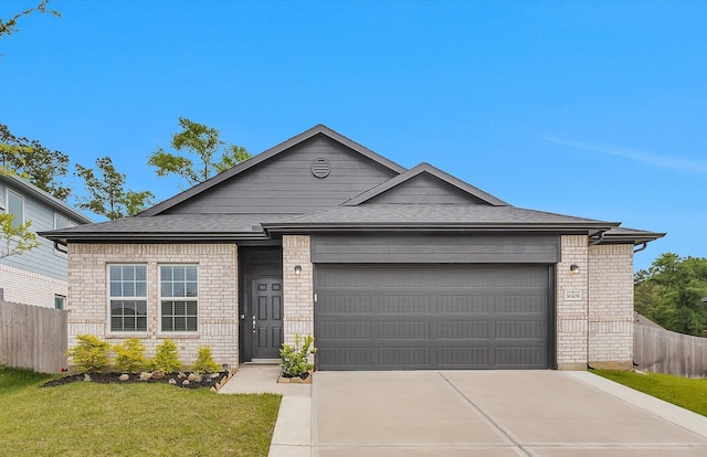 single story home featuring driveway, brick siding, fence, an attached garage, and a shingled roof