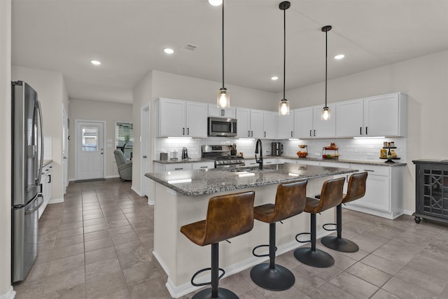 kitchen with a sink, decorative backsplash, white cabinets, and stainless steel appliances