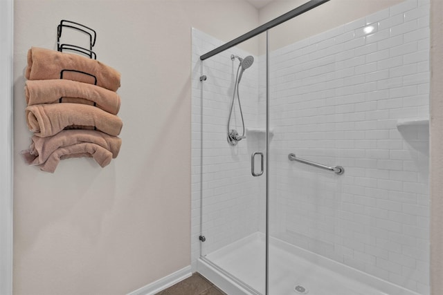 full bathroom featuring baseboards and a stall shower
