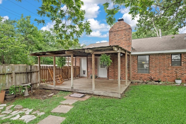 227 Oak Hollow St, Conroe, TX 77301 - back of property with a chimney, a wooden deck, brick siding, fence, and a yard
