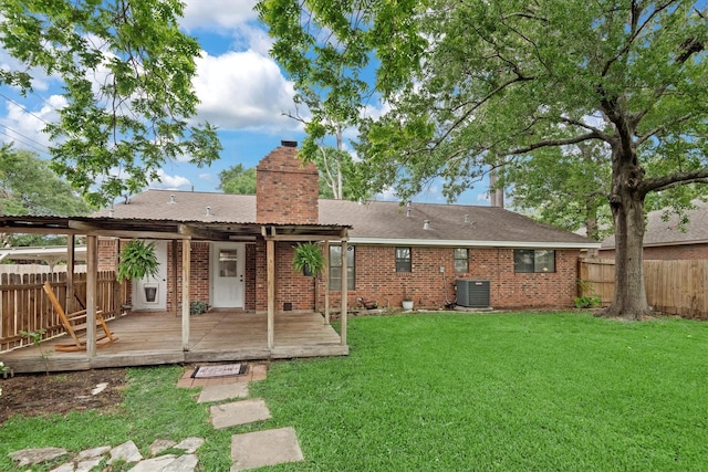 227 Oak Hollow St, Conroe, TX 77301 - rear view of property featuring a deck, a fenced backyard, a chimney, central air condition unit, and a lawn